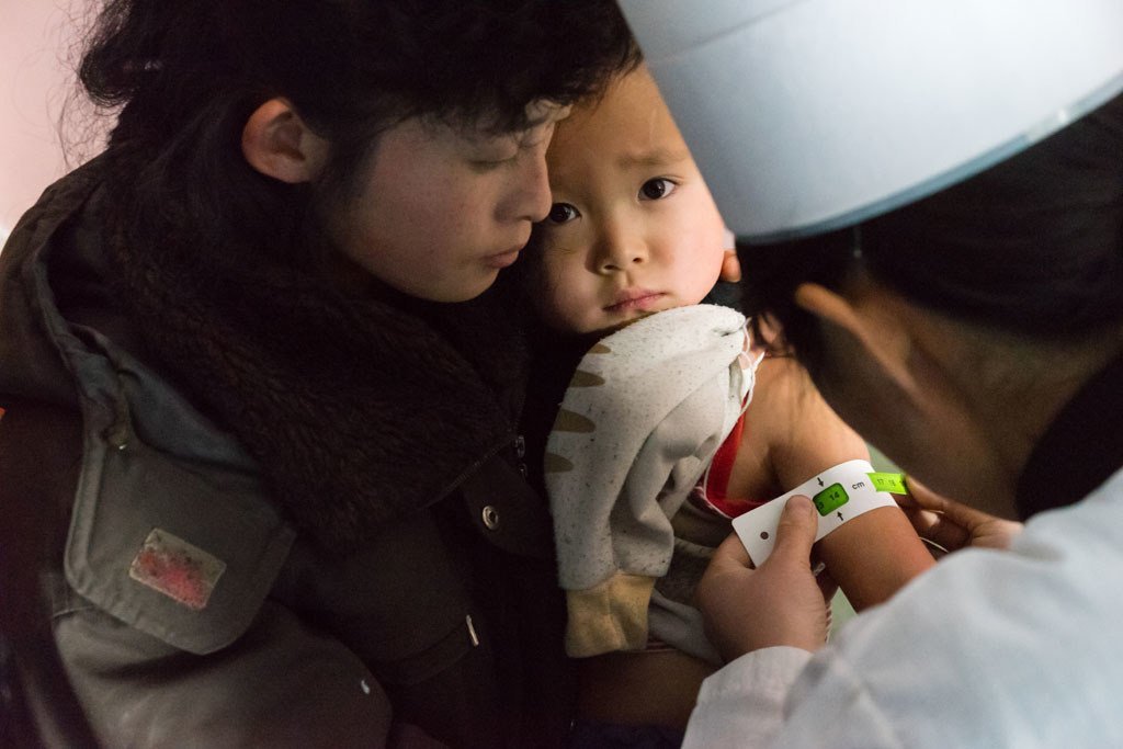 一名朝鲜儿童在诊所接受营养状况检查、免疫接种，以及维生素A和驱虫治疗。去年，在朝鲜工作的人道主义机构为33万5千名儿童进行了免疫，并为400万人提供医疗保健服务。