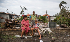 Mereani y sus hijos sentados en una de las paredes de ladrillo de lo que solía ser su hogar en Fiji. Su casa estaba a sólo unos metros de la costa y sufrió grandes daños durante las fuertes oleadas de tormenta causadas por el paso del ciclón Winston.