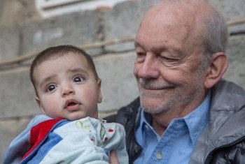 Executive Director of UNICEF Anthony Lake with an eight-month-old infant who lives with his family in Alsamah neighbourhood, Iraq.