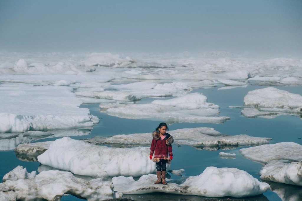 Une fille de la communauté Iñupiat debout sur une banquise au bord de l'océan Arctique à Barrow, en Alaska, aux États-Unis. La fonte anormale de la glace arctique est l’un des nombreux effets du réchauffement planétaire.