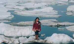 Une jeune fille de la communauté d'Inupiat sur un morceau de banquise à Barrow, en Alaska, aux États-Unis. Photo UNICEF/Vlad Sokhin