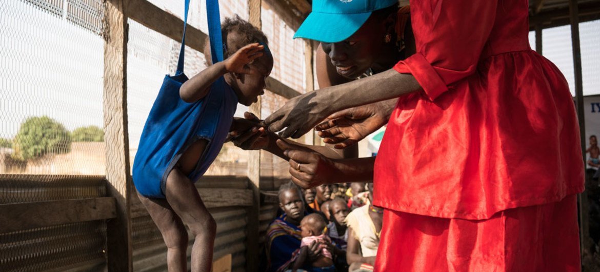 儿基会营养部门专家正在南苏丹对一名13个月大的婴儿进行营养不良筛查。儿基会/Mackenzie Knowles-Coursin