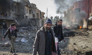 A family climbs out of their destroyed home to flee minutes after an ISIS suicide car bomber detonated his vehicle on the street outside their home in the Al Andalus neighbourhood of Mosul, Iraq. Photo: UNHCR/Ivor Prickett