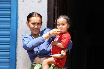 Une grand-mère nourrit sa petite-fille de deux ans à Naubise, Dhading, au Népal.