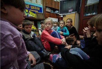 Estudiantes de primer grado ucranianos, entre ellos Sasha, de 6 años y con camisa roja, participan en unas prácticas para refugiarse en caso de bombardeo. 