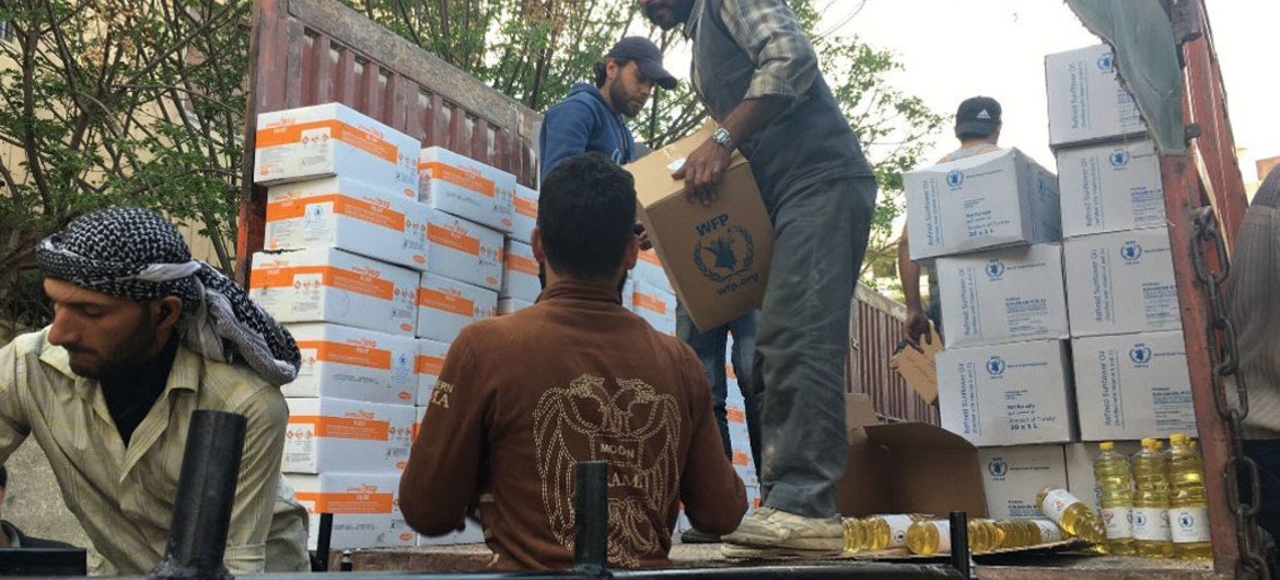 Сотрудники ООН разгружают помощь для 35 тысяч сирийцев в труднодоступных городах Ялда, Бабила и Бейт-Сахам в провинции Дамаск. Фото ВПП