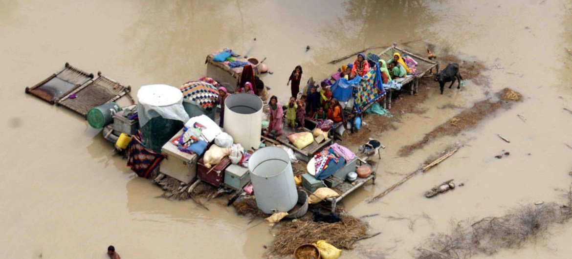 Пакистанская семья пытается спастись от наводнения Фото ИФАД