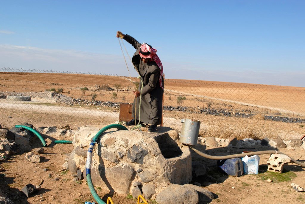 مزارع يقوم بسحب مياه البئر لري محاصيله في ريف الأردن.