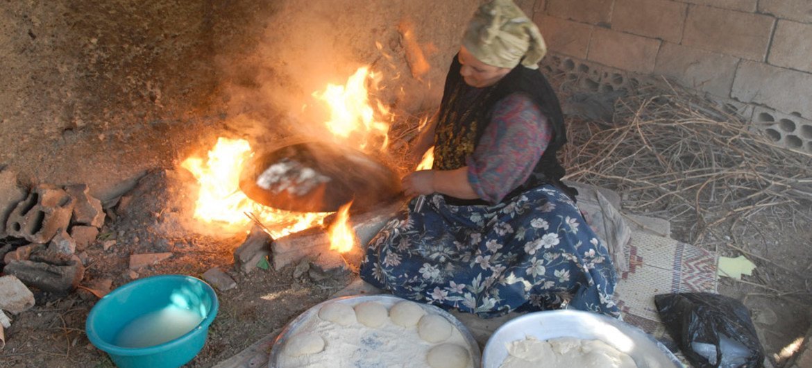 A woman prepares bread at her home in Faqua village, Jordan for sale in the local market. Since her husband passed away in 2002, she has had to take care of her family of nine children. With her small business of bread, cheese and Jabeen (dry yogurt) she 