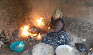 A woman prepares bread at her home in Faqua village, Jordan for sale in the local market. Since her husband passed away in 2002, she has had to take care of her family of nine children. With her small business of bread, cheese and Jabeen (dry yogurt) she earns enough to survive.