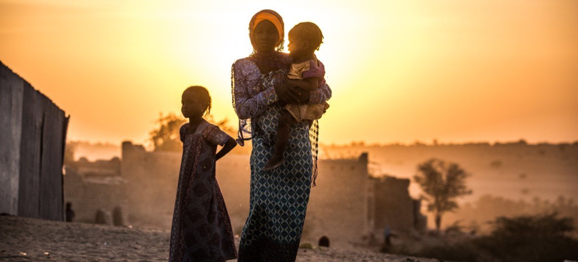在乍得的一个村庄，一名女孩抱着妹妹，另一个妹妹站在她身边。儿基会图片/Tremeau