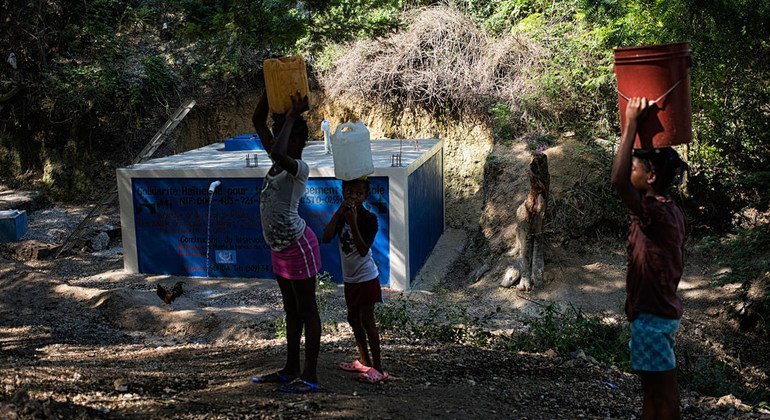 Haitianos reciben agua potable en Puerto Príncipe. 