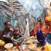 أطفال نازحون مع أمهم في مخيم للنازحين داخليا في بايدوا بالصومال.