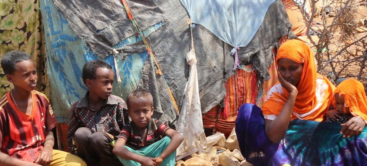 أطفال نازحون مع أمهم في مخيم للنازحين داخليا في بايدوا بالصومال.