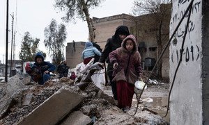 A family displaced by fighting between ISIS and Iraqi security forces carry their belongings as they walk through the destroyed western neighbourhood of Al Mamum, near Mosul, Iraq.