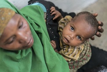 Un jeune garçon souffrant de malnutrition porté par sa mère dans un centre de programme thérapeutique ambulatoire soutenu par l'UNICEF à Baidoa, en Somalie.