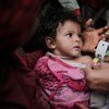 医生正在对也门萨那一名患有急性营养不良的儿童进行筛查。