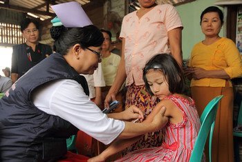 Une enfant se faisant vaccinée dans un centre de vaccination établi dans le canton de Hlaing Thar Yar, à Yangon, au Myanmar.