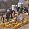People queue to fill containers with water from a tank provided by UNICEF in Sana'a, Yemen. Some 14.5 million people in the country have no access to safe drinking water and adequate sanitation.