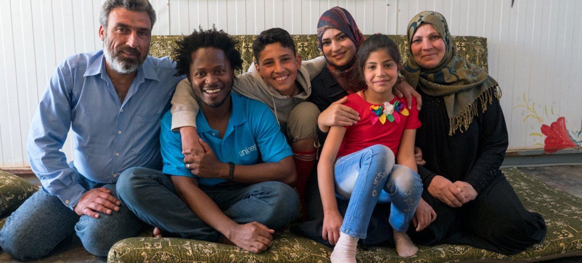 UNICEF Advocate Ishmael Beah with a displaced family at the Za'atari refugee camp in Jordan.