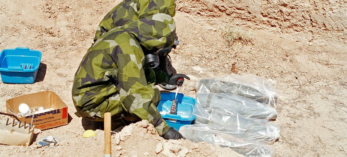 Inspetores coletam amostras de agente de mostarda de projéteis de artilharia de 155 mm, que foram embrulhados em plástico para minimizar a contaminação no Iraque em 1991