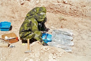 Inspetores coletam amostras de agente de mostarda de projéteis de artilharia de 155 mm, que foram embrulhados em plástico para minimizar a contaminação no Iraque em 1991