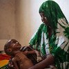 Двухлетний ребенок  на руках у матери  плачет  из-за недоедания. Фото  МОМ