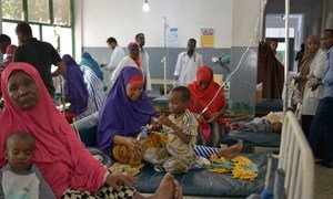 Malnourished children, many of them suffering from diarrhea, lie on beds in Banadir hospital in Mogadishu, Somalia, while their parents and hospital staff tend to them.