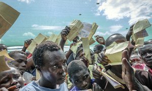 Waving their forms, recently arrived South Sudanese refugees demand to be registered at Imvepi reception centre in Arua district in Northern Uganda.