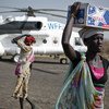 Women carry emergency food supplies from a World Food Programme (WFP) helicopter that landed in Thanyang, South Sudan.