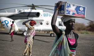 Des femmes transportent des vivres d'urgence depuis un hélicoptère du Programme alimentaire mondial (PAM) qui a atterri à Thanyang, au Soudan du Sud.