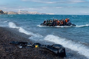 Des réfugiés rient et saluent alors que le zodiac dans lequel ils se trouvent s’approche du rivage, près du village de Skala Eressos, sur l’île de Lesbos, en Grèce.
