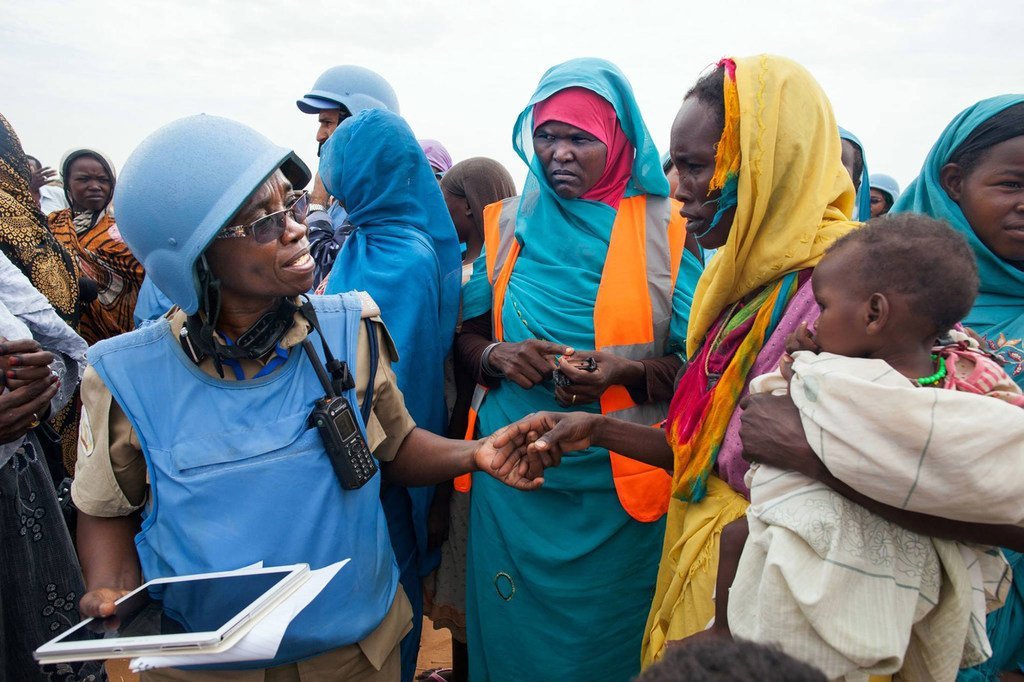 UNAMID police officer Grace Ngassa (Tanzania) and Community Policing Volunteer Jazira Ahmad Mohammad interact with a woman in the Zam Zam camp for internally displaced persons in North Darfur. 