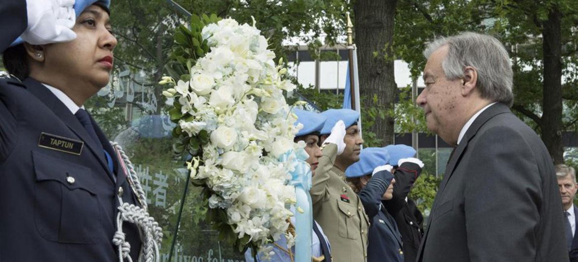 Le Secrétaire général António Guterres (à droite) dépose une couronne de fleurs en l'honneur de tous les Casques bleus qui ont perdu la vie au service de l'ONU. Photo ONU/Mark Garten
