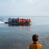 Un niño observa desde la costa una embarcación de refugiados acercándose a la isla de Lesbos, en Grecia. Foto: UNICEF/Ashley Gilbertson VII