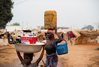 Displaced people carry belongings through the M'Poko airport camp in Bangui, Central African Republic.