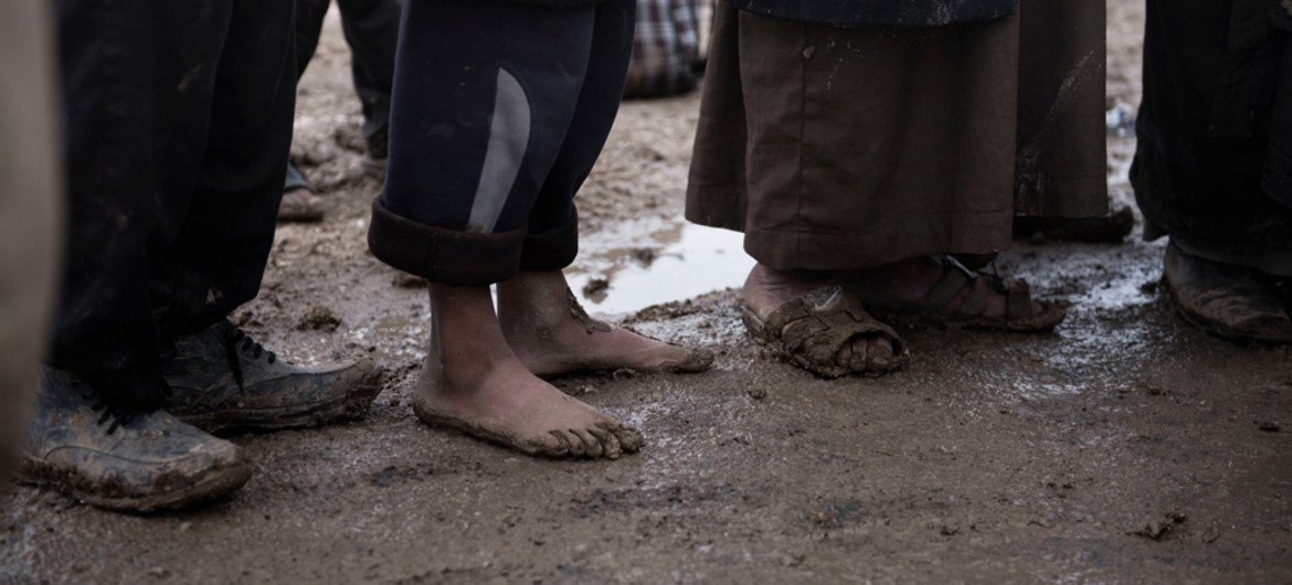 A child stands barefoot alongside other children, after they fled with their families from fighting between ISF and ISIL in an area west of Mosul, Iraq. Many of those fleeing are using the cover of night to evade ISIL snipers.
