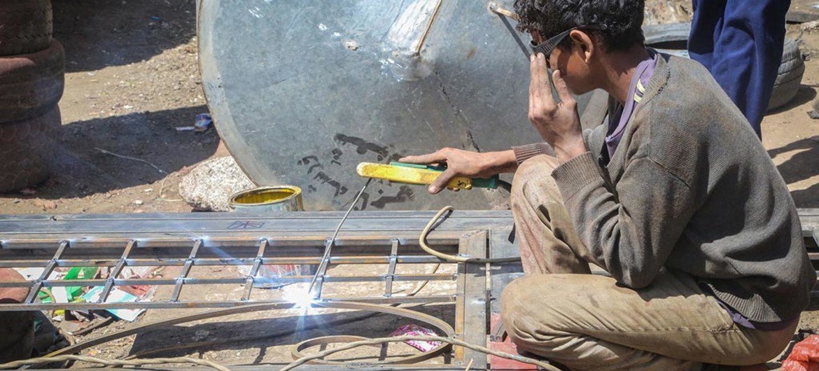 A fifteen-year-old child works to weld a frame in Sana’a, Yemen.