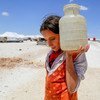 十二岁的伊拉克流离失所女孩Ain Issa举着一罐水。到2030年让所有人都能公平获得安全和可负担得起的清洁水是第六项可持续发展目标。 