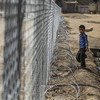 A young boy stands next to a fence surrounding the football pitch at Al-Shuhadaa Stadium in the city of Iskandariya, Babil Governorate, Iraq. UNICEF/Khuzaie