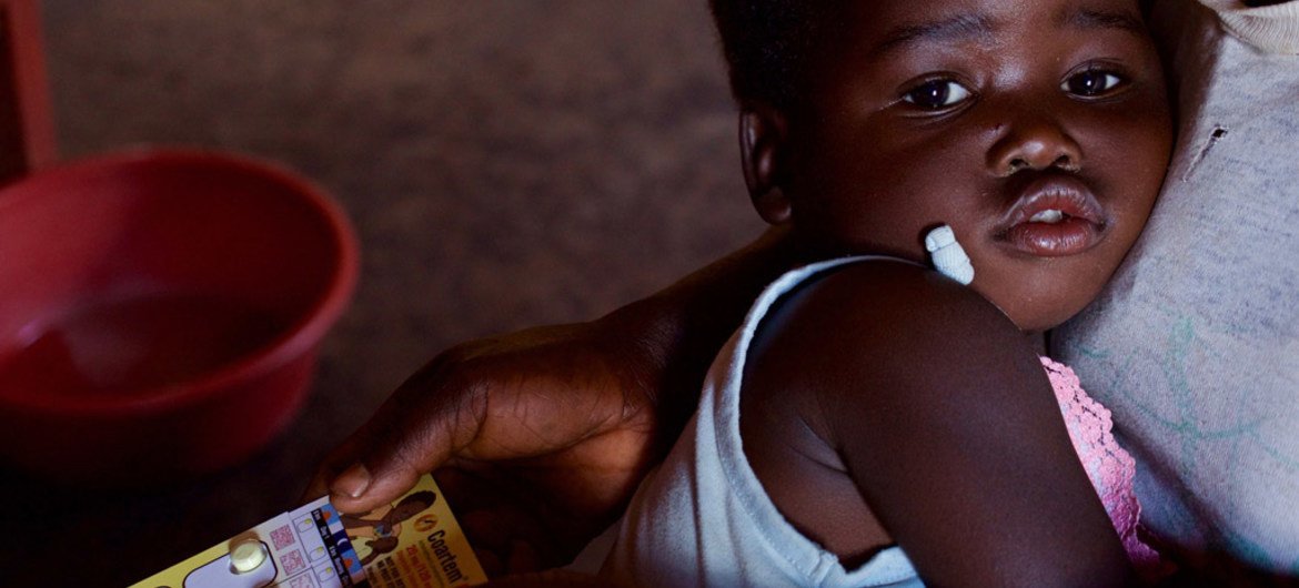 Une fille de deux ans, dans les bras de sa mère, reçoit un médicament pour traiter le paludisme dans une clinique communautaire du district rural de Kasungu, au Malawi.