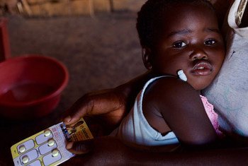 A two-year-old girl is held by her mother as she is prescribed a course of medication to treat malaria at a community clinic in rural Kasungu district, Malawi.