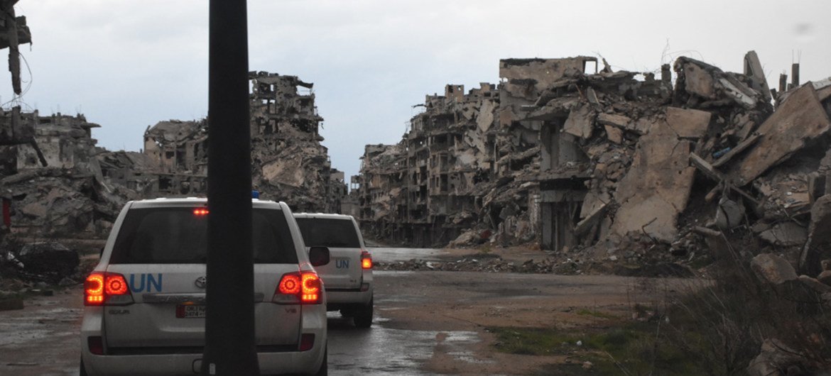 Un convoi de l'UNICEF passe devant des bâtiments détruits à Homs, en Syrie.