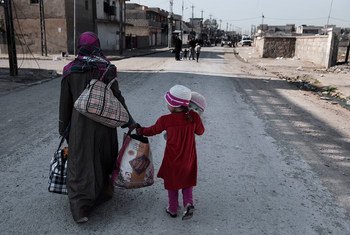 Une femme et son enfant fuient les combats qui opposent les forces de sécurité iraquiennes et l’EIIL dans le quartier Al-Mamoon, à l'ouest de Mossoul, en Irak en mars 2017.