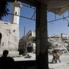 من الأرشيف: طلاب مدرسة يمرون بين المباني المدمرة في معرة النعمان بسوريا.