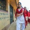 A 16-year-old girl advocate against child marriage walks to school, passing the words “Now is not the time to get married, never marry before the age of 18,” in her village in Giridih, Jharkhand state, India. (file)