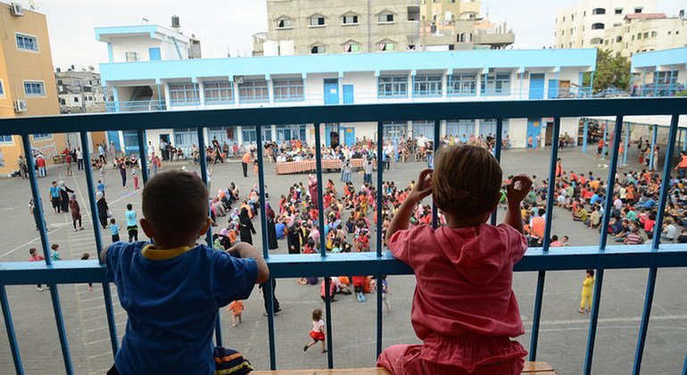 Dos niños se asoman a los balcones del centro colectivo Bahrain en Gaza, donde siguen albergados desde que sus casas fueran destruidas en 2014. 