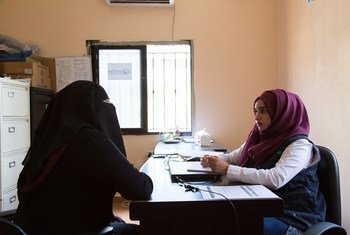 A gender-based violence caseworker (right) listens to a refugee.