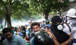 المتظاهرون في لا كاستيانا، أحد أحياء كاراكاس، يهربون من قنابل الغاز المسيل للدموع التي أطلقها الحرس الوطني والشرطة الوطنية البوليفارية. 18 أيار/مايو 2017.