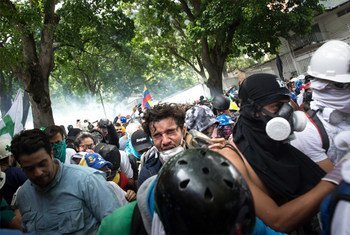 المتظاهرون في لا كاستيانا، أحد أحياء كاراكاس، يهربون من قنابل الغاز المسيل للدموع التي أطلقها الحرس الوطني والشرطة الوطنية البوليفارية. 18 أيار/مايو 2017.